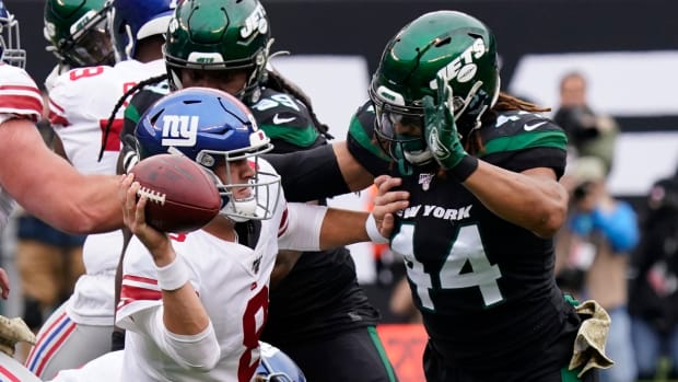 Nov 10, 2019; East Rutherford, NJ, USA; New York Giants quarterback Daniel Jones (8) barely gets the ball off under pressure from New York Jets linebacker Harvey Langi (44) at MetLife Stadium.